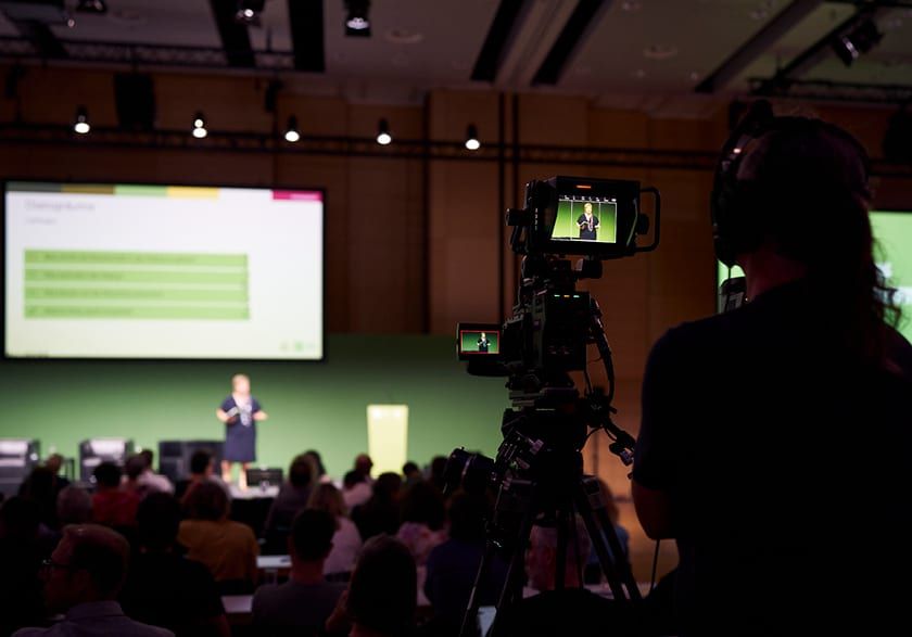 Blick aus dem Publikum auf Barbara Guwak, die auf einer gro&szlig;en B&uuml;hne pr&auml;sentiert